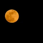 Luna portocalie răsărind la orizont, explicată prin fenomenul de dispersie a luminii