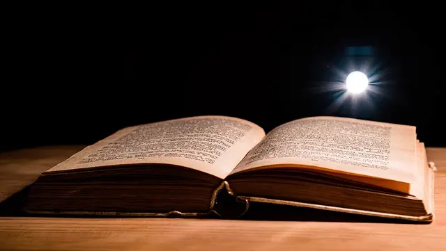 Carte veche deschisă sub o rază de lumină simbolizând cunoașterea pierdută Biblioteca din Alexandria